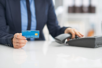Closeup on business woman with credit card dialing phone