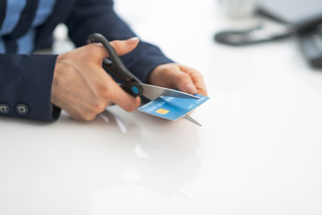 Closeup on business woman cutting credit card with scissors