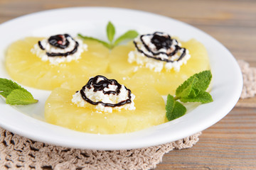 Tasty pineapple with cottage cheese on  wooden table