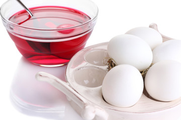 Eggs with liquid colour in glass bowl isolated on white