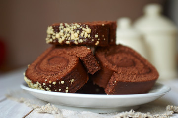 Chocolate cake-roll on a white saucer