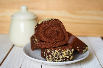 Chocolate cake-roll on a white saucer