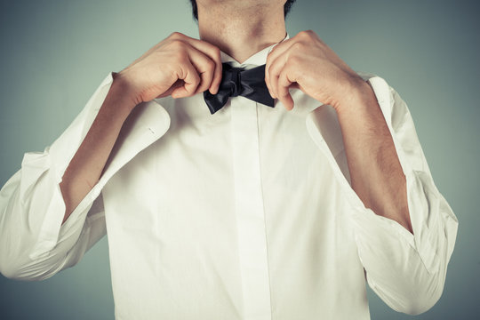 Young man tying a bow tie
