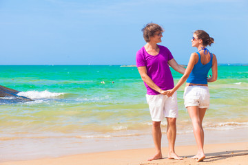front view of couple holding hands on tropical beach