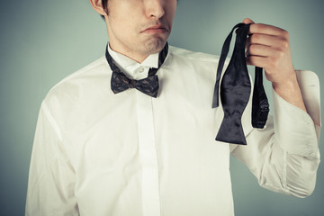 Young man holding a bow tie