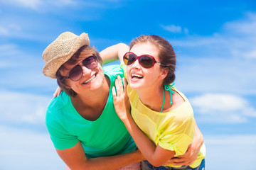 Closeup of happy young couple in sunglasses on beach smiling