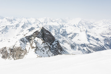 Fototapeta na wymiar Snow covered slope with mountain ridge in the back