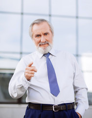 Senior businessman pointing at viewer