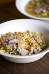 yellow thai pork noodle on wooden table