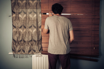 Peeping tom looking through blinds