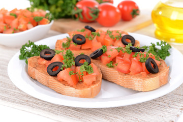 Delicious bruschetta with tomatoes on plate on table close-up