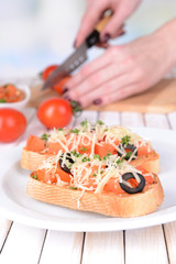 Delicious bruschetta with tomatoes on plate on table close-up