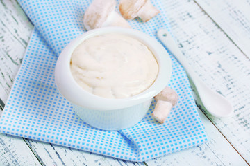 Delicate mushroom sauce in bowl on wooden table close-up