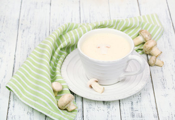 Delicate mushroom sauce in cup on wooden table close-up