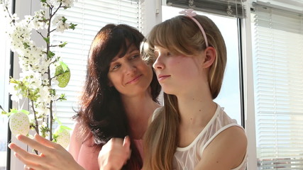 Happy family with child hang easter egg.
