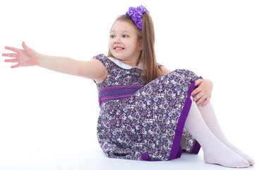 charming little girl sitting on the floor.
