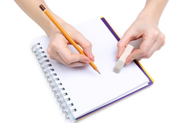 Human hands with pencil and erase rubber and notebook, isolated