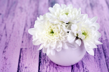 Beautiful chrysanthemum flowers in vase on wooden table
