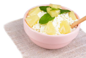 Bowl of tasty cottage cheese with pineapple, isolated on white