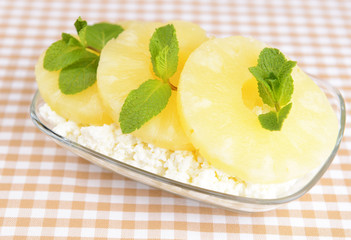 Bowl of tasty cottage cheese with pineapple, close up
