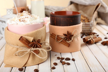 Fototapeta na wymiar Mug of hot drink decorated in felt on wooden table