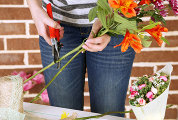 Fototapeta na wymiar Female hands composing beautiful bouquet, close-up. Florist at
