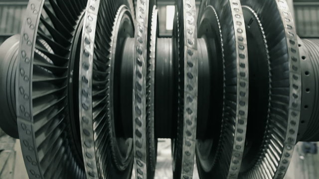 frontal shot of spinning steam turbine at workshop