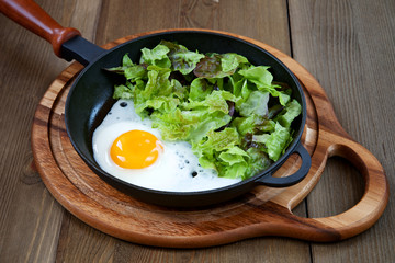 Fried egg in a frying pan with a green salad