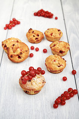 Muffin with red currants  on a white wooden table