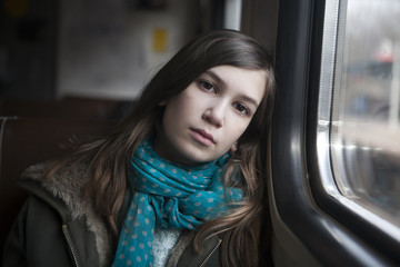 Naklejka na ściany i meble teenager girl sits in the carriage looking through window