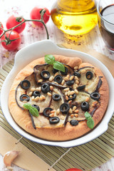 Vegetarian pizza with eggplants, olives and pine nuts