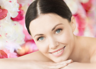 Obraz na płótnie Canvas smiling woman in spa lying on the massage desk