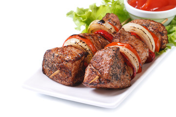 skewers of meat with vegetables isolated on white plate
