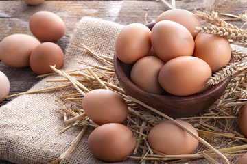 Healthy domestic eggs in a wooden bowl on a rustic table
