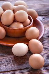 Healthy domestic eggs in a wooden bowl on a rustic table