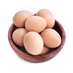 Healthy domestic eggs in a wooden bowl on a white background