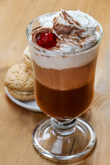 Irish coffee and stack of cookies on wooden table