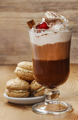 Irish coffee and stack of cookies on wooden table