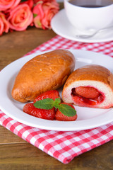 Fresh baked pasties with strawberries on plate on table