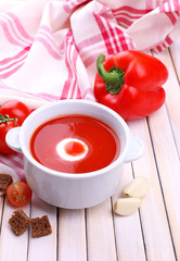 Tasty tomato soup and vegetables on wooden table