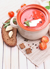 Tasty tomato soup and vegetables on wooden table