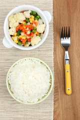 Cooked rice with vegetables on wooden table