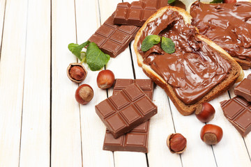 Bread with sweet chocolate hazelnut spread on wooden background