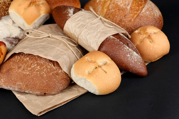 Different types of bread on black background, close-up