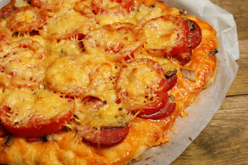 Homemade pizza on baking paper close up