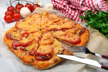 Homemade pizza on baking paper close up