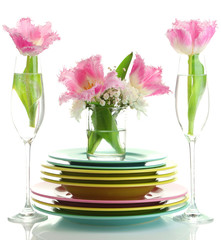 Stack of colorful ceramic dishes and flowers, isolated on white