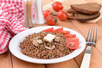 Boiled buckwheat on plate on table close-up