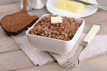 Boiled buckwheat in bowl on table close-up
