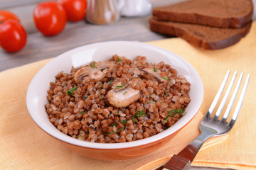 Boiled buckwheat in bowl on table close-up